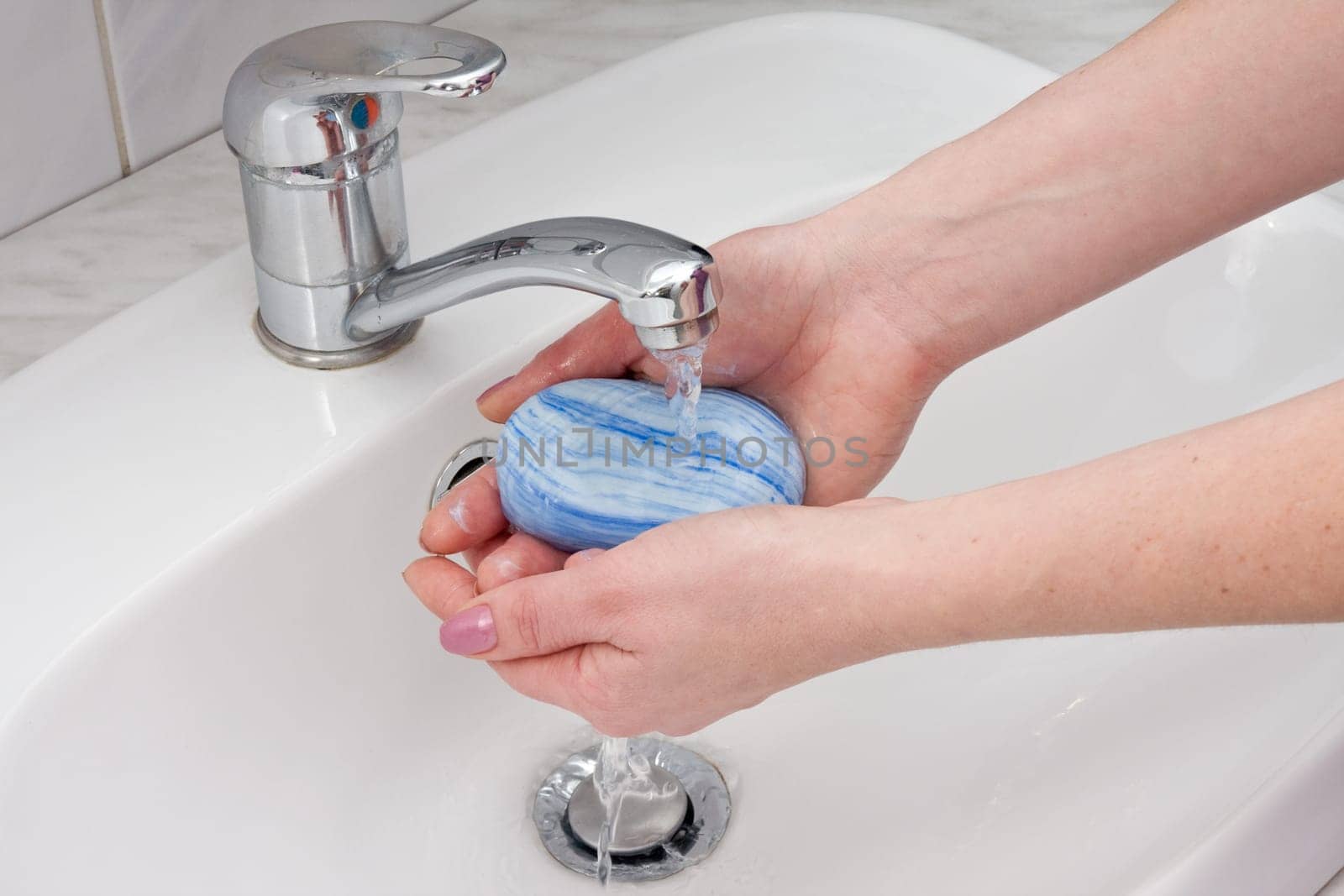 human hands being washed under stream of pure water