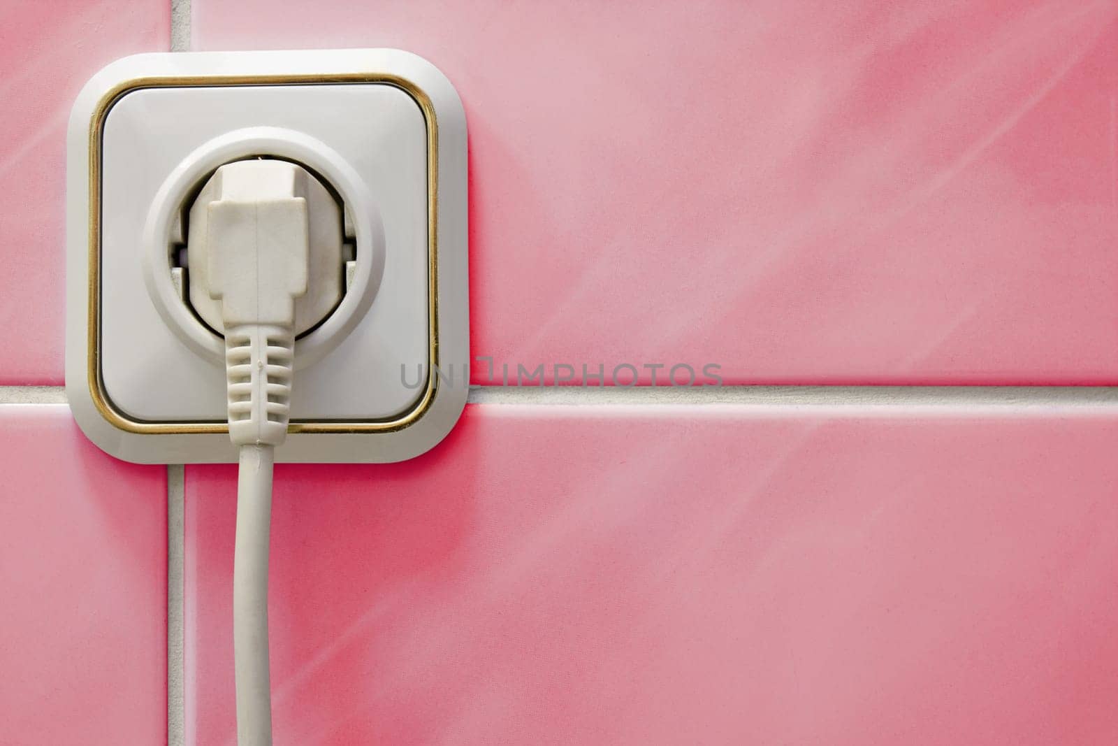 white outlet with a electric plug in a bathroom