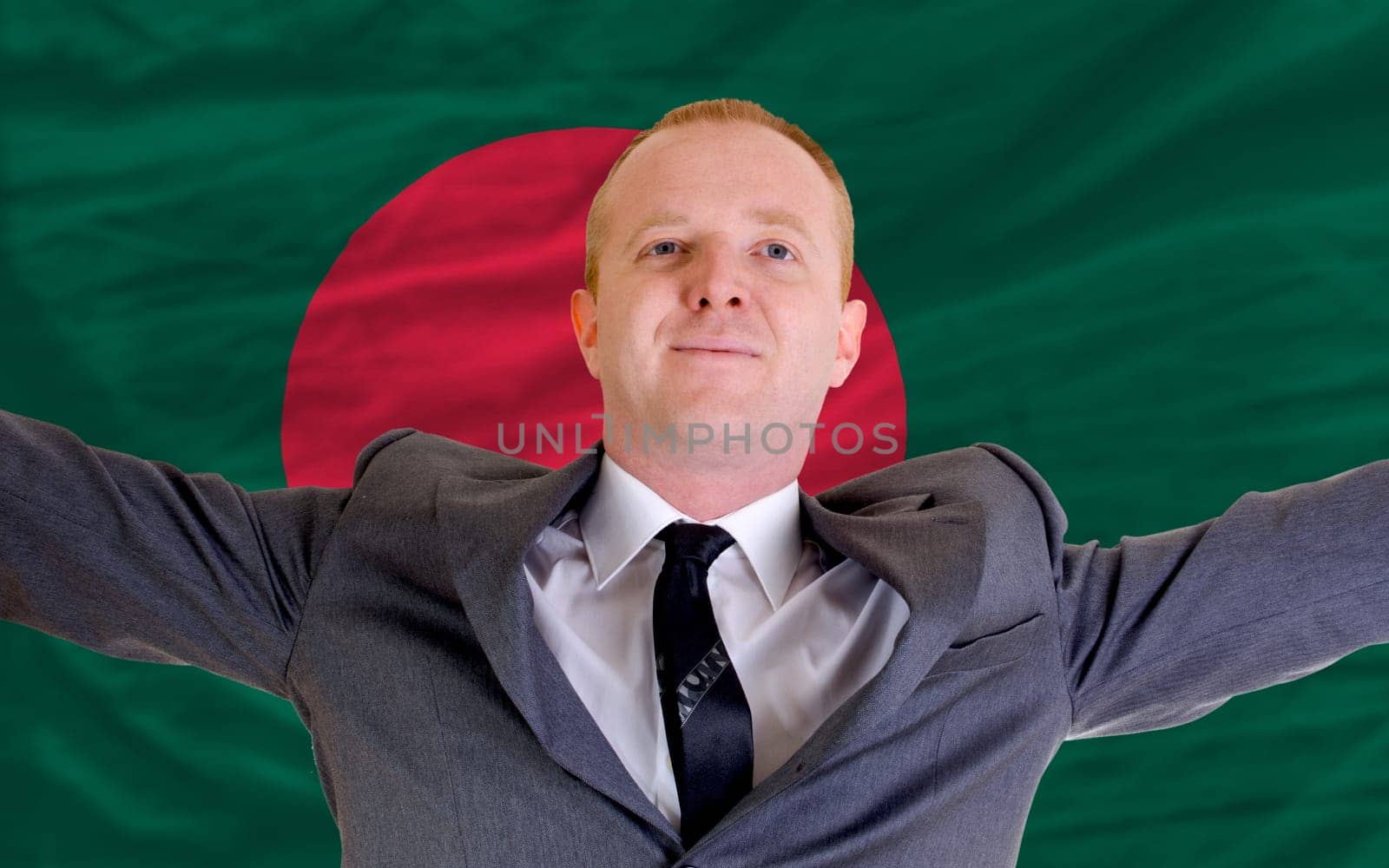joyful investor spreading arms after good business investment in bangladesh, in front of flag