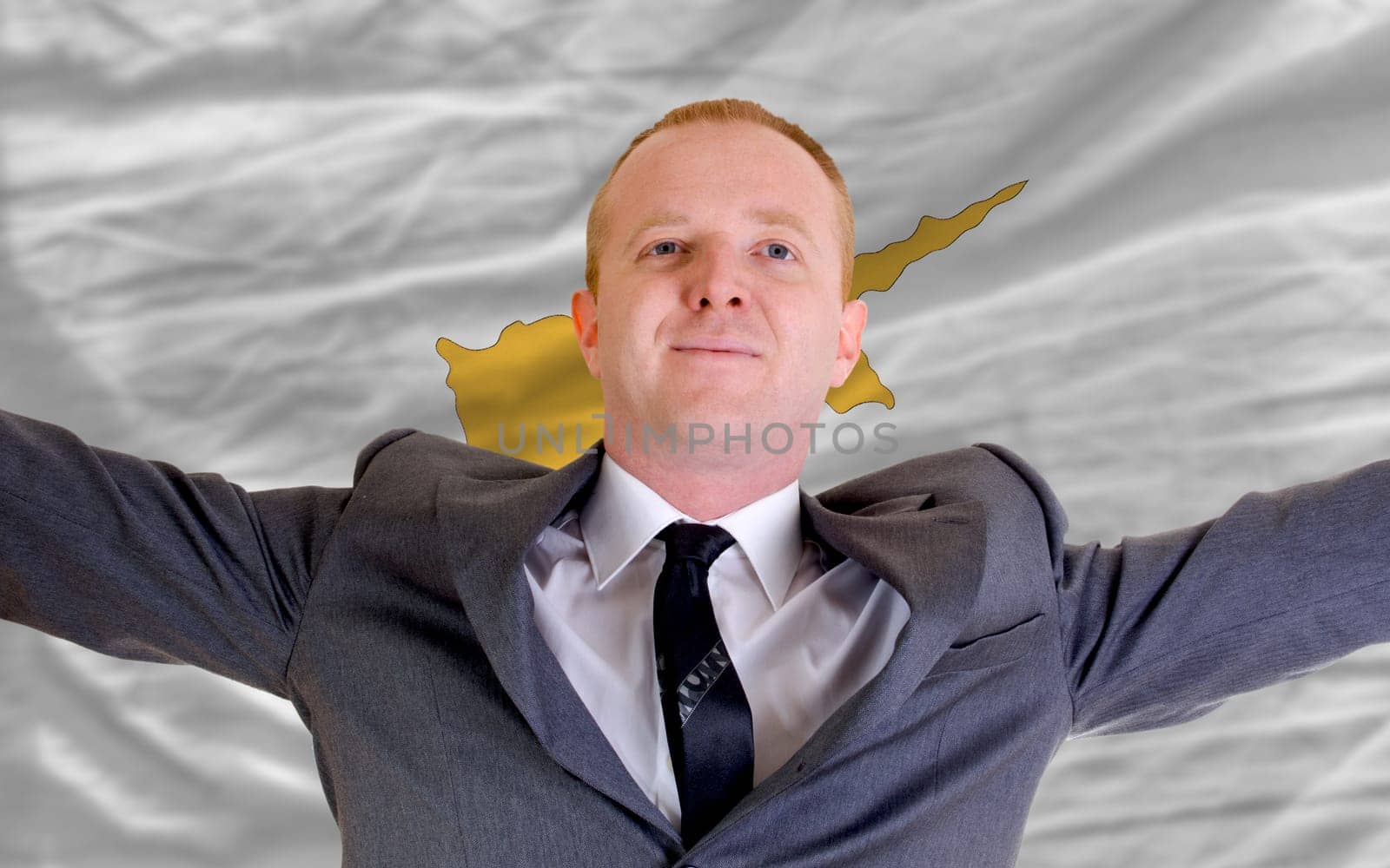 joyful investor spreading arms after good business investment in cyprus, in front of flag