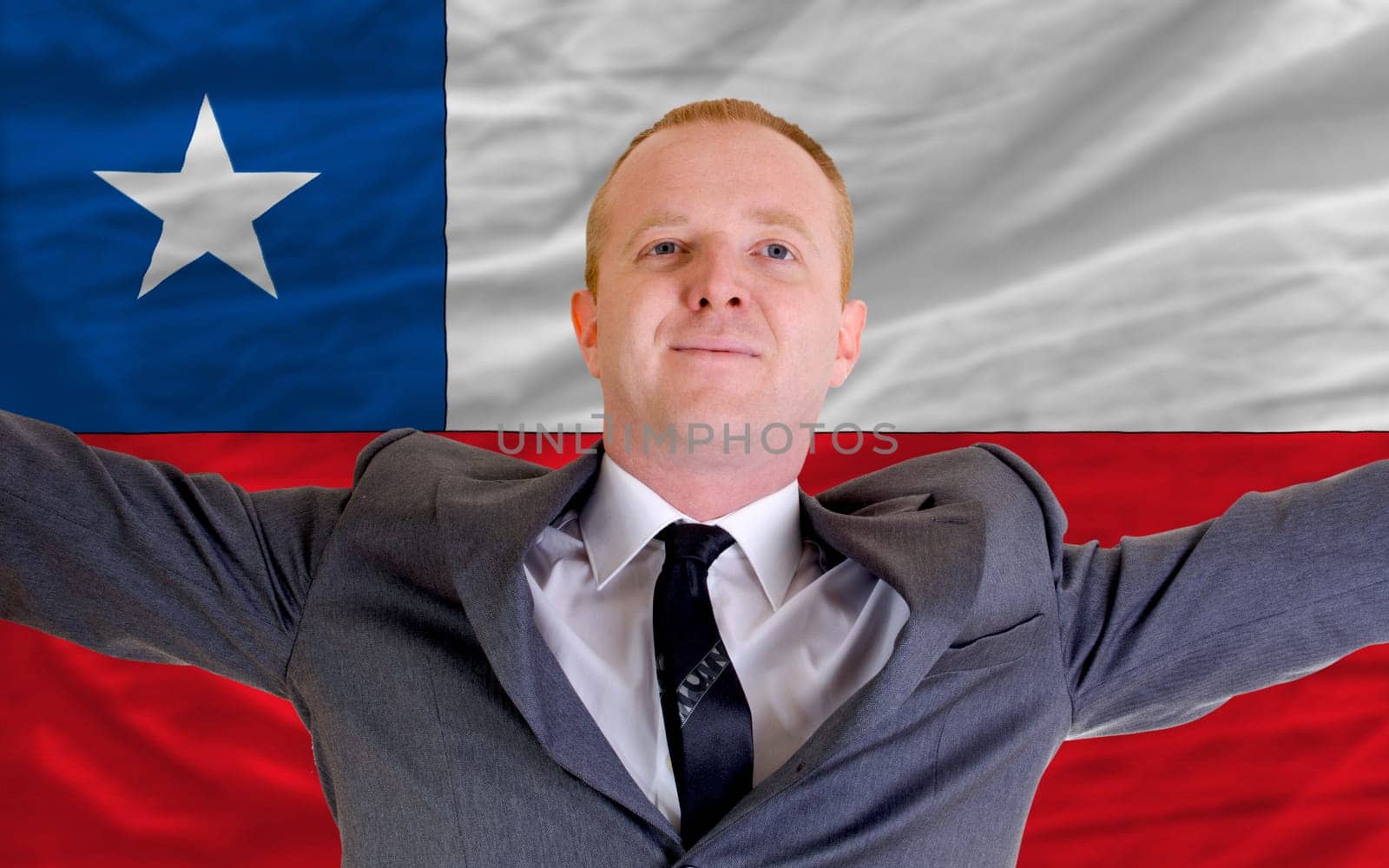 joyful investor spreading arms after good business investment in chile, in front of flag