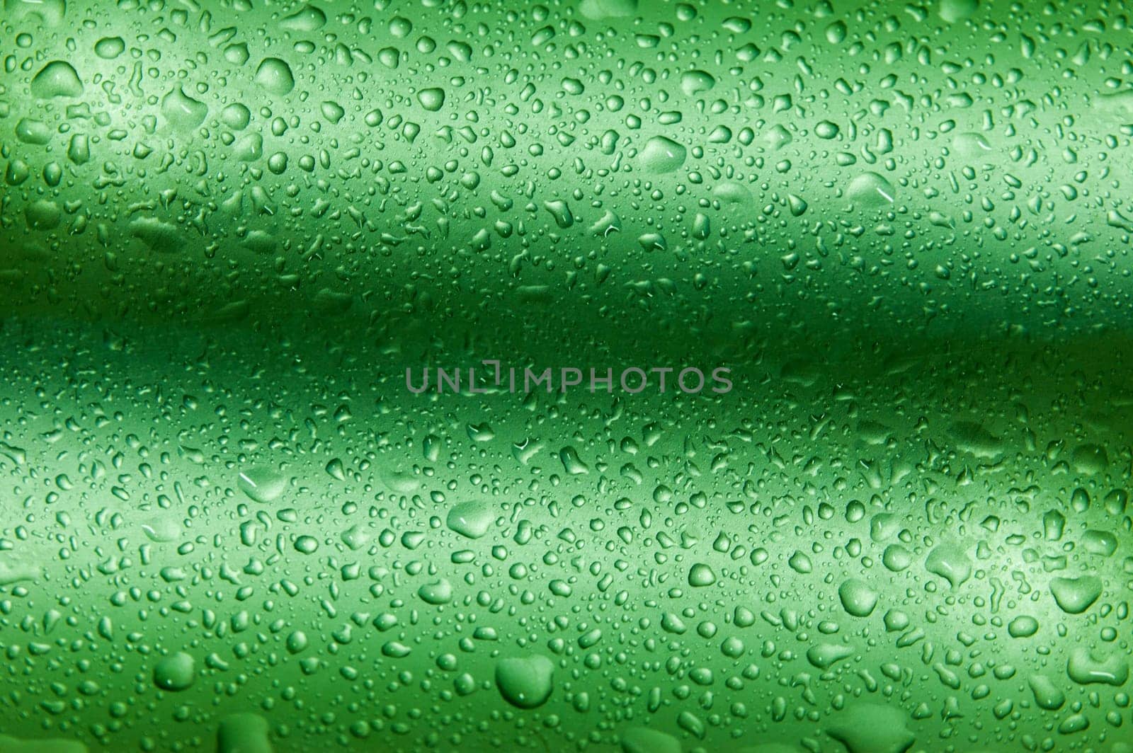 Many drops on green wavy background making texture