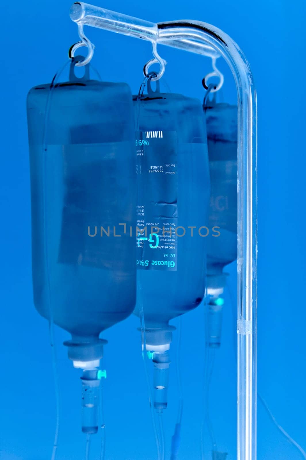 Shaded three infusion bottles hanging on metal holder