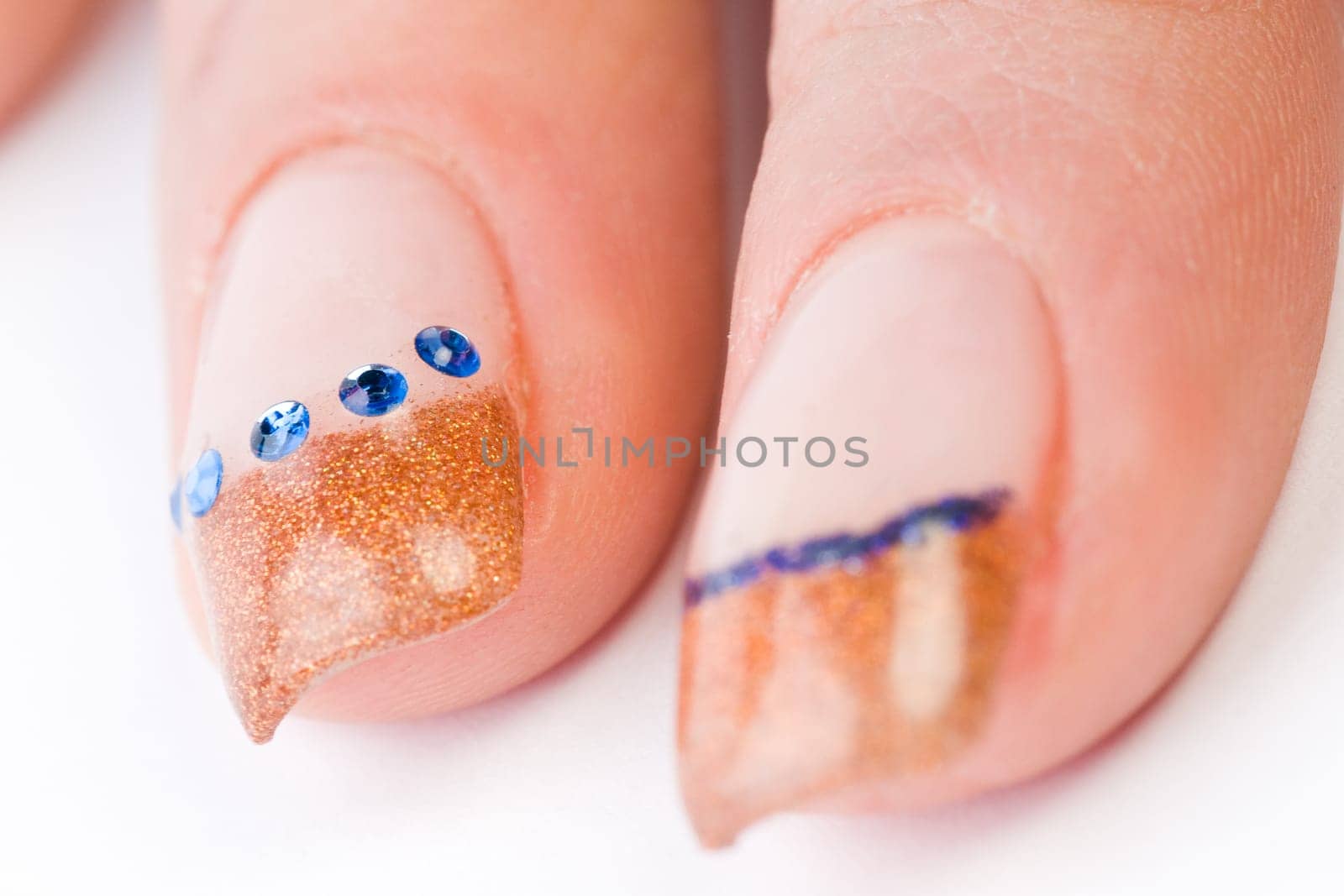 Beautiful female well-groomed colorful fingernails against white background