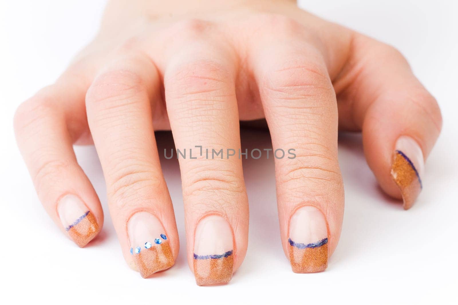 Beautiful female well-groomed colorful fingernails against white background