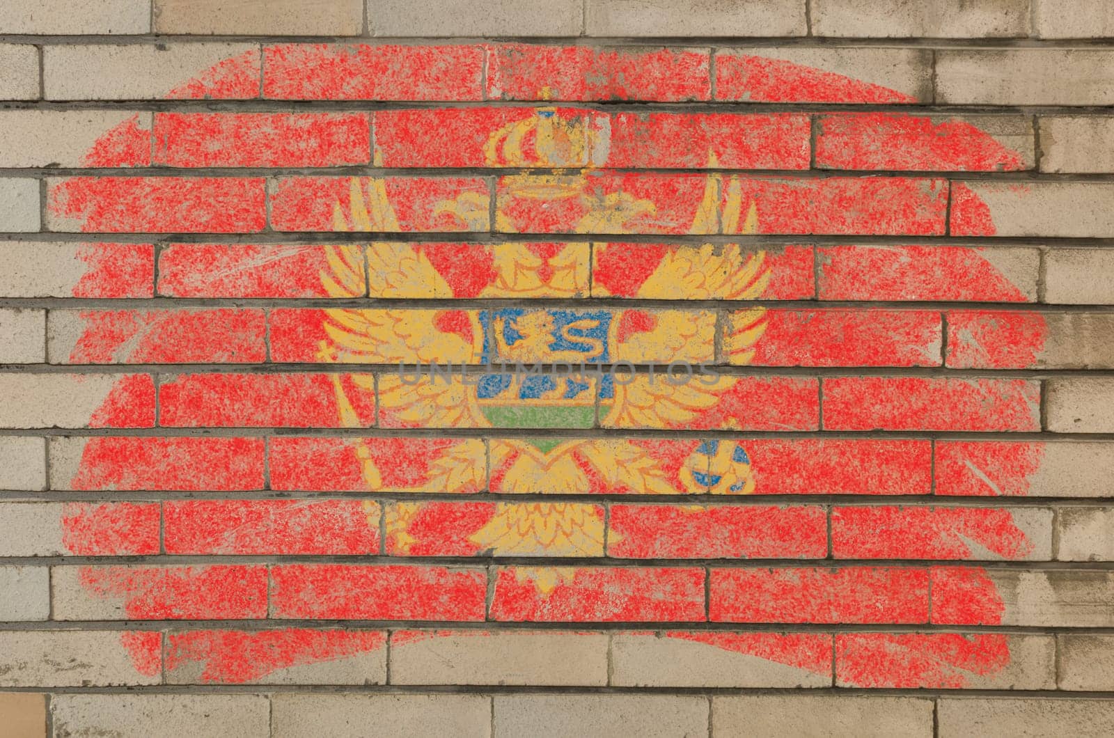 Chalky montenegrian flag painted with color chalk on grunge old brick wall