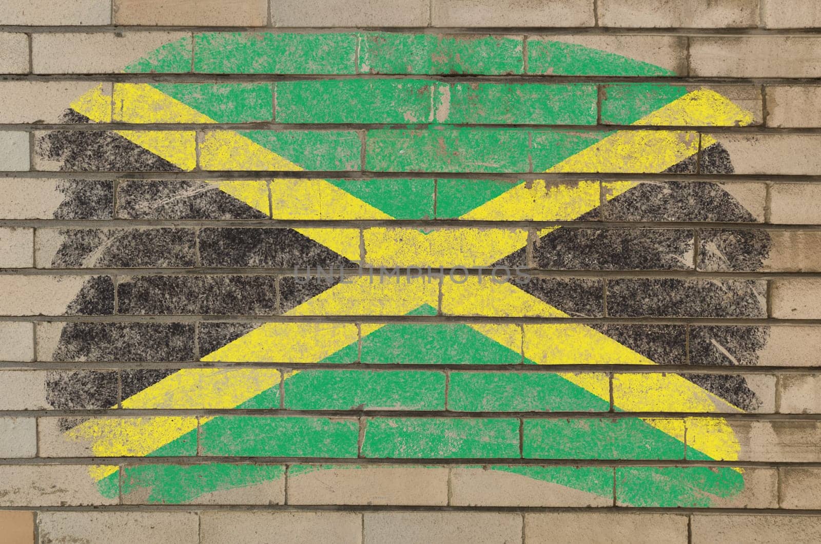 Chalky jamaican flag painted with color chalk on grunge old brick wall