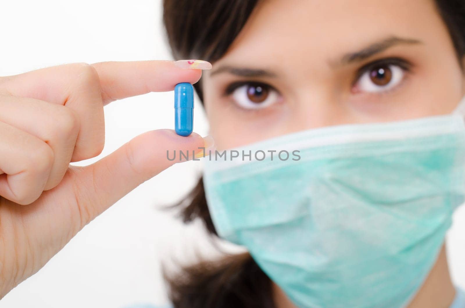 Blue pill in a woman&#039 s hand, isolated an a white background