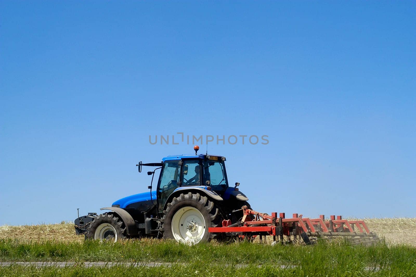 The harvest of colza with machines like a reaping-machine threshing-machine and tractor