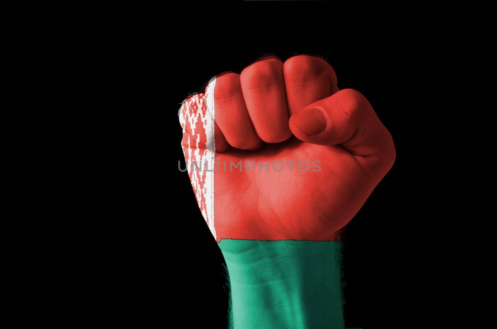 Low key picture of a fist painted in colors of belarus flag