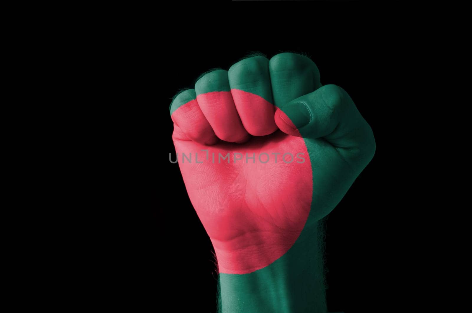 Low key picture of a fist painted in colors of bangladesh flag