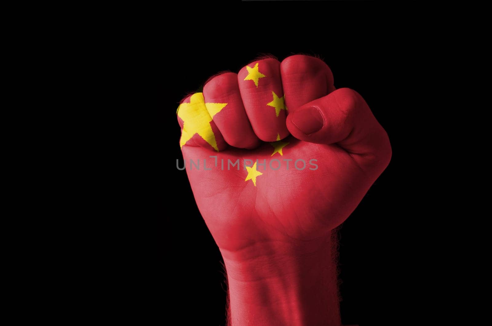 Low key picture of a fist painted in colors of china flag