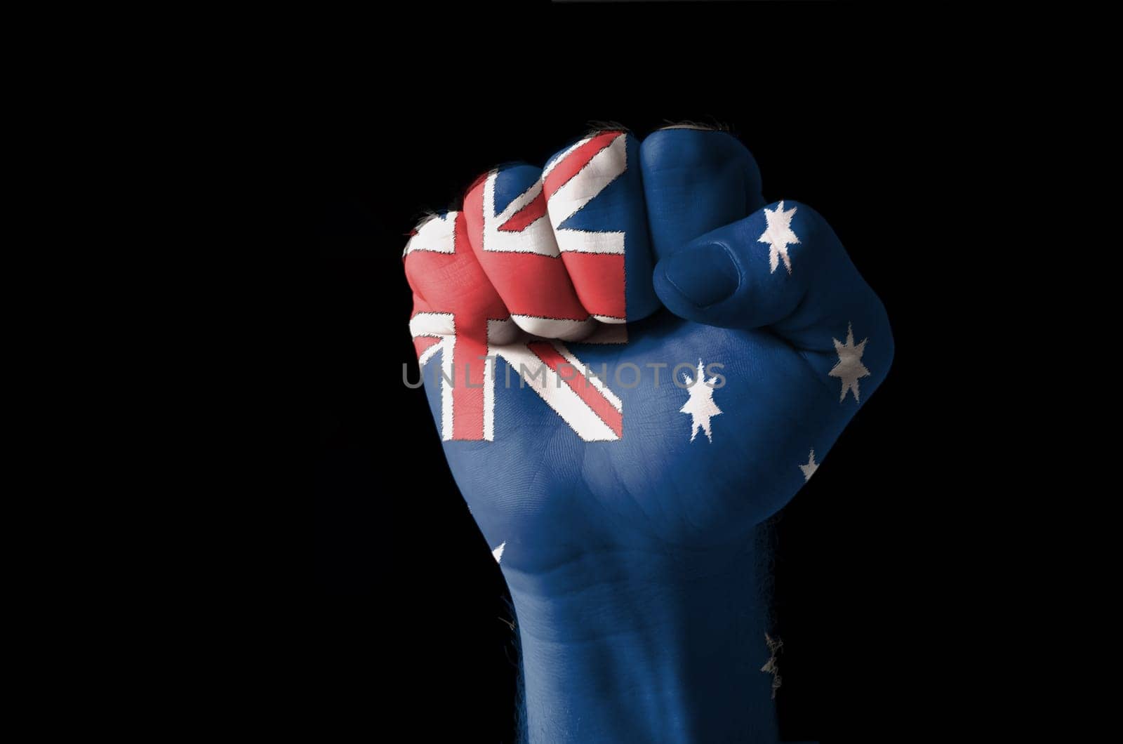 Low key picture of a fist painted in colors of australia flag