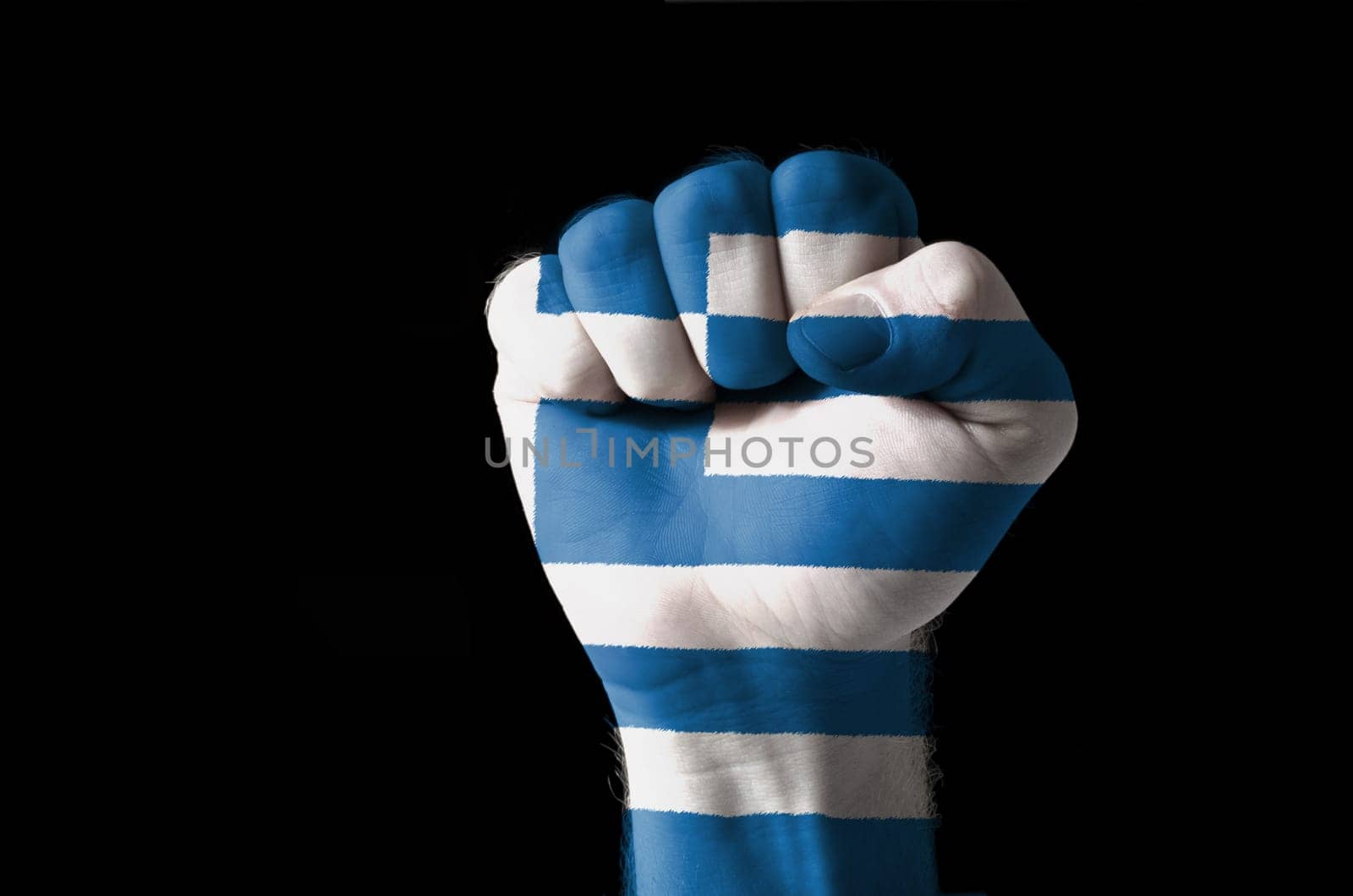 Low key picture of a fist painted in colors of greece flag