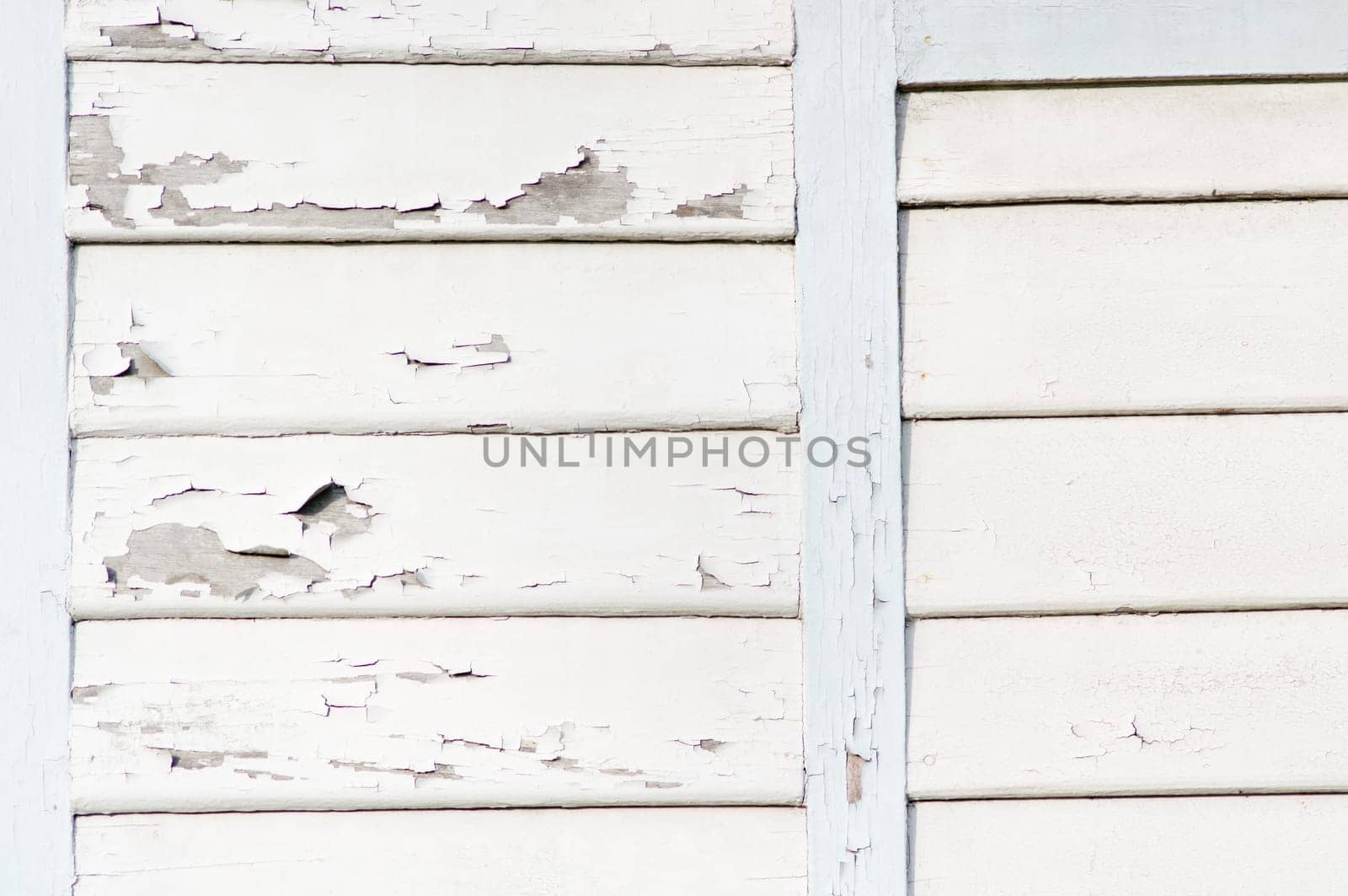 wooden wall with peeling white paint.