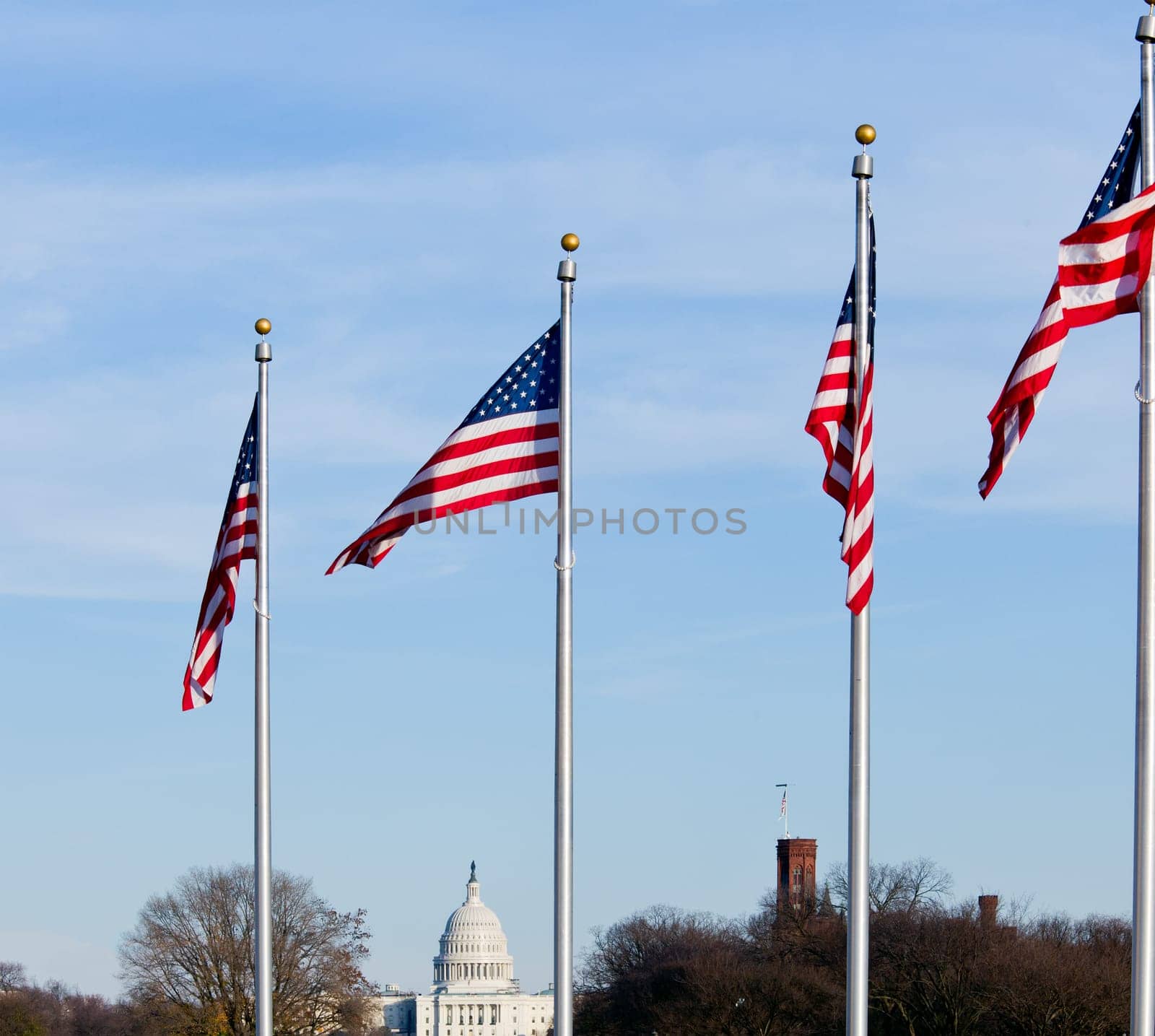 Capitol dome on a clear winter day with stars and stripes flag in foreground