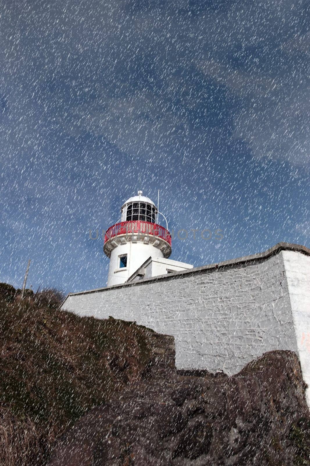 lighthouse during a rain storm on the rocks in youghal county cork ireland