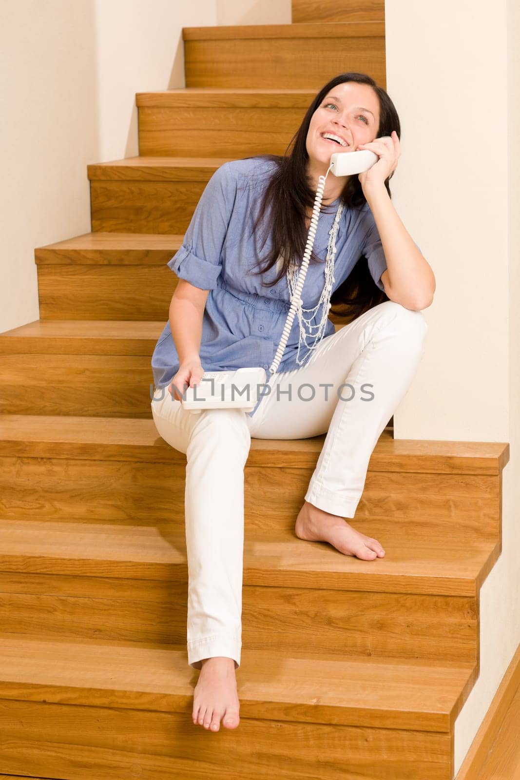 Home living happy young woman calling phone sitting on staircase