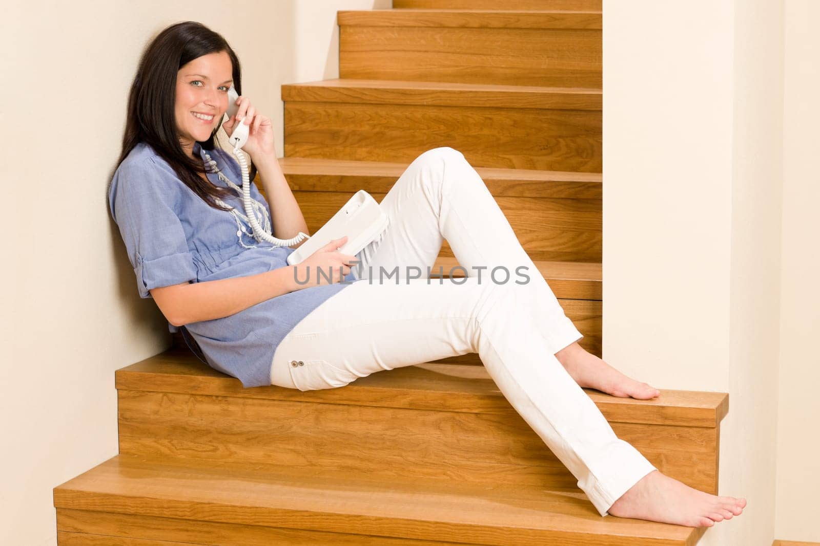 Home living happy young woman calling phone sitting on staircase