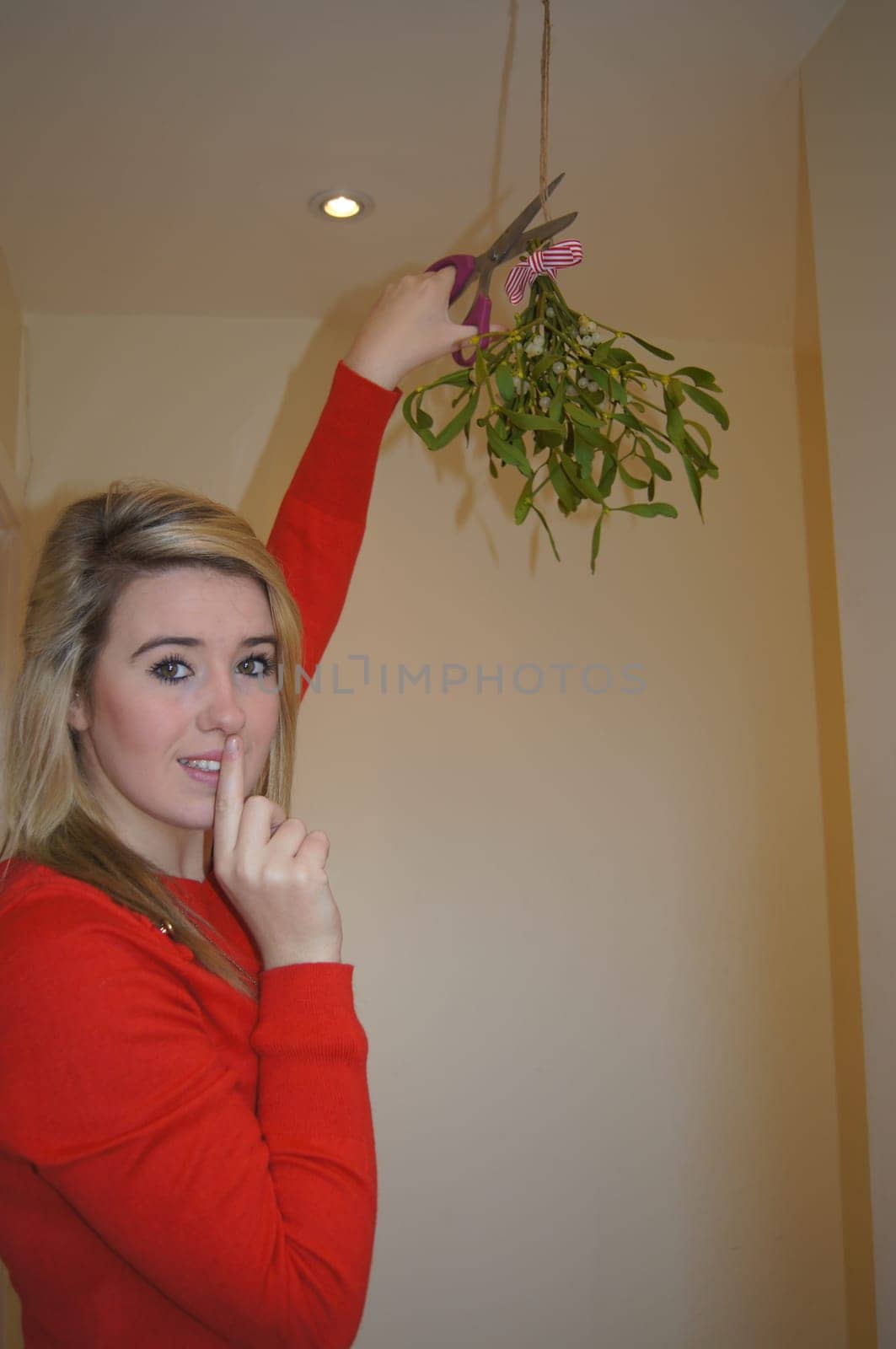 Girl secretly cutting down the mistletoe