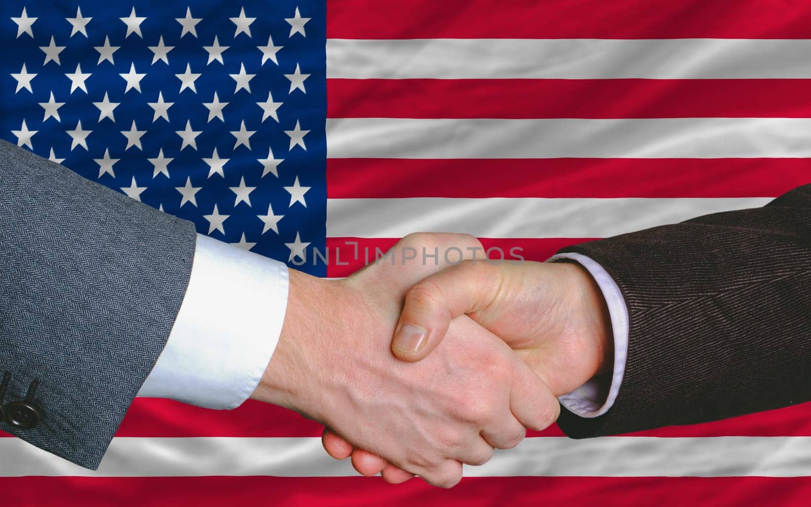 two businessmen shaking hands after good business investment  agreement in america, in front of flag
