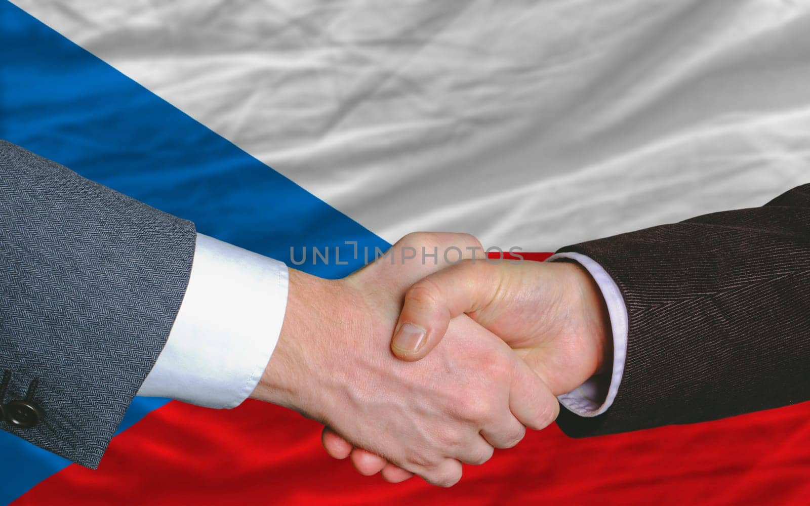 two businessmen shaking hands after good business investment  agreement in czech, in front of flag