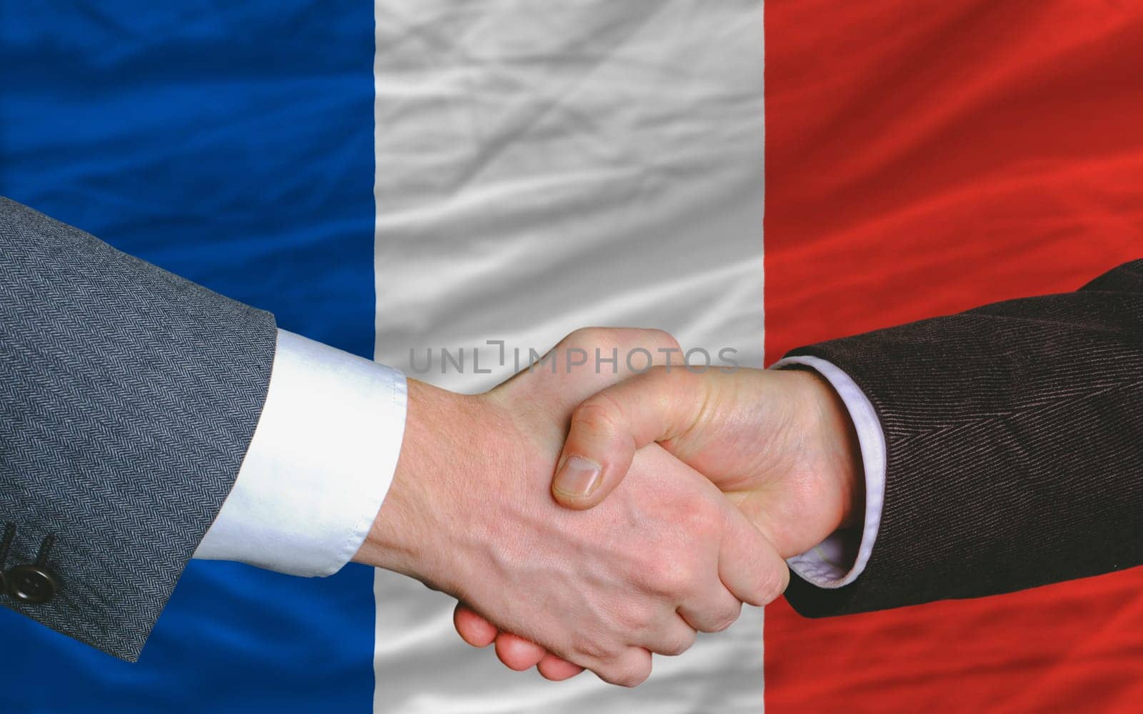 two businessmen shaking hands after good business investment  agreement in iceland, in front of flag