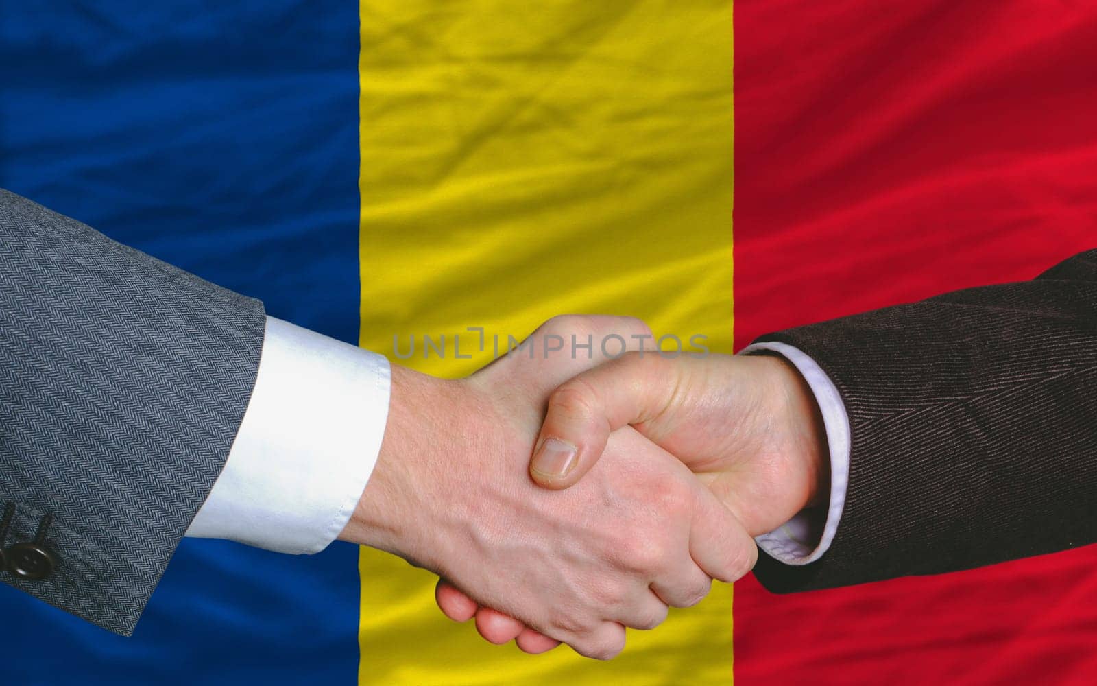 two businessmen shaking hands after good business investment  agreement in romania, in front of flag