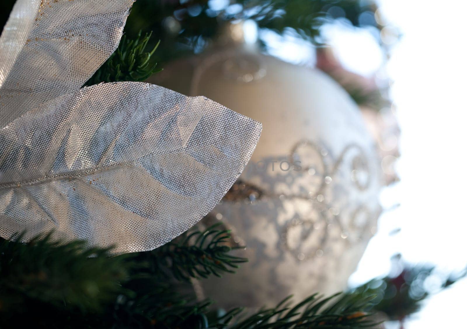 Christmas tree decorated with silver and white ribbons and ornaments in family home