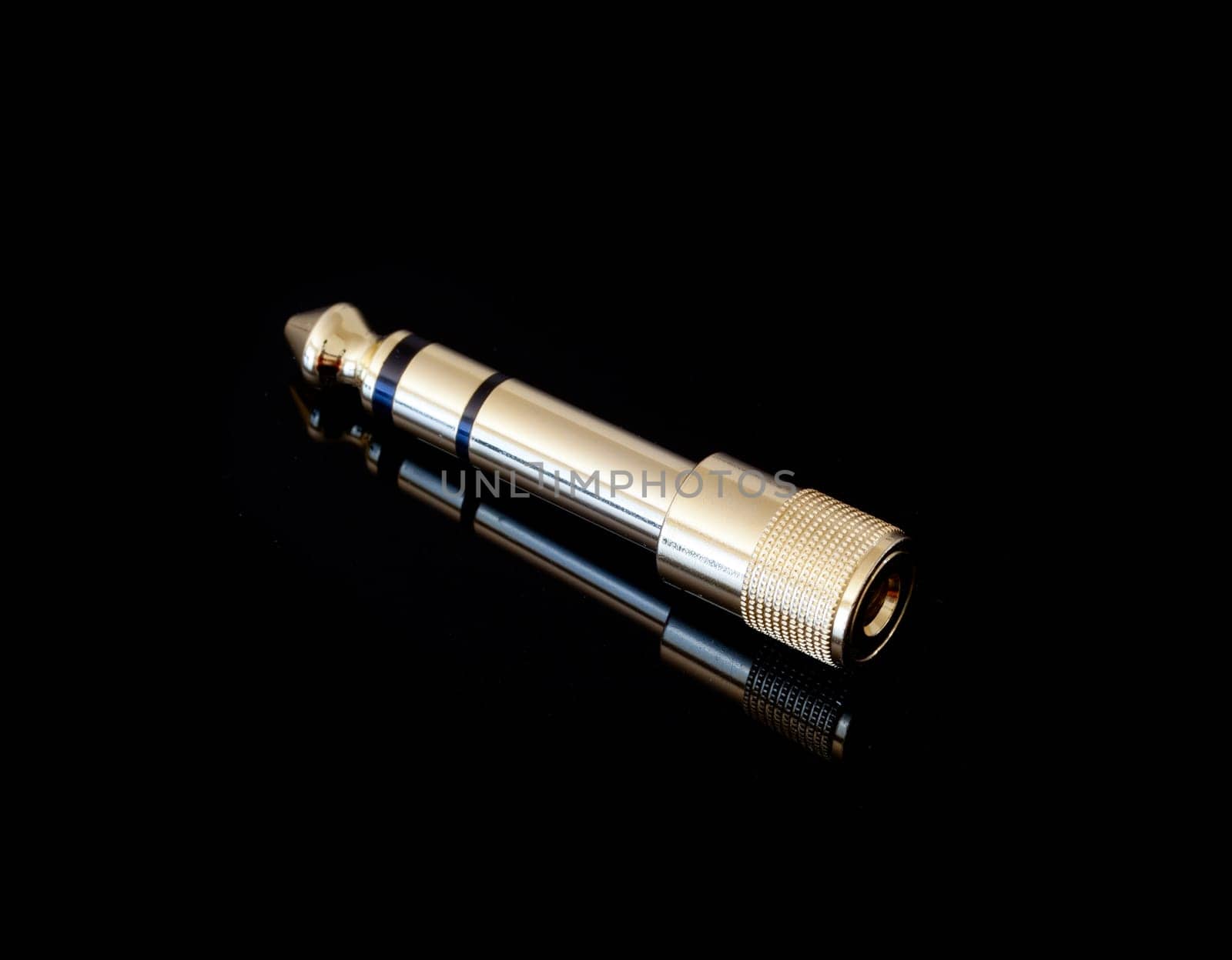 Adapter that converts one eighth inch to one quarter inch jack plugs used on headphones and microphones
