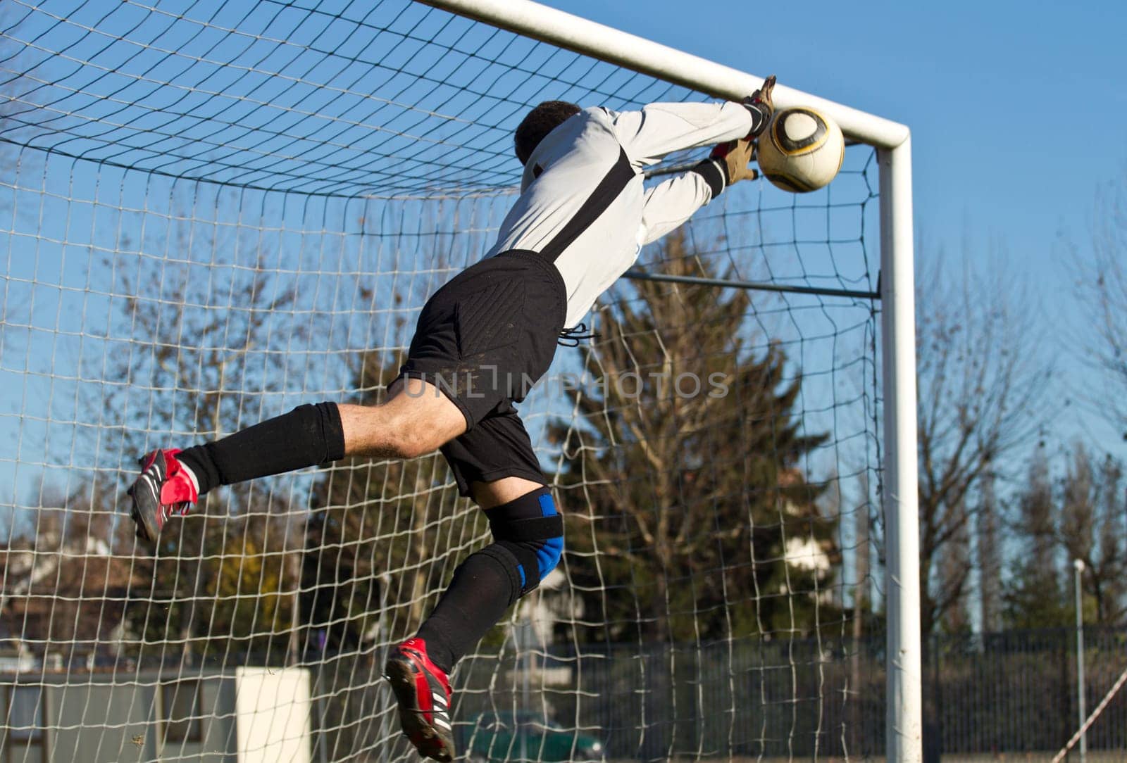 Soccer football goalkeeper making diving save