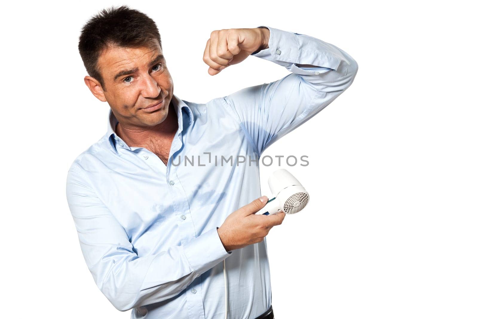 one caucasian man with sweat stain perspire drying shirt with hair dryer in studio isolated on white background