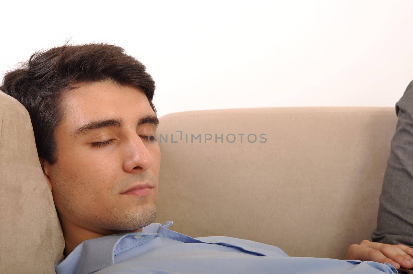close-up portrait of an attractive young man sleeping on the couch (isolated on white background)