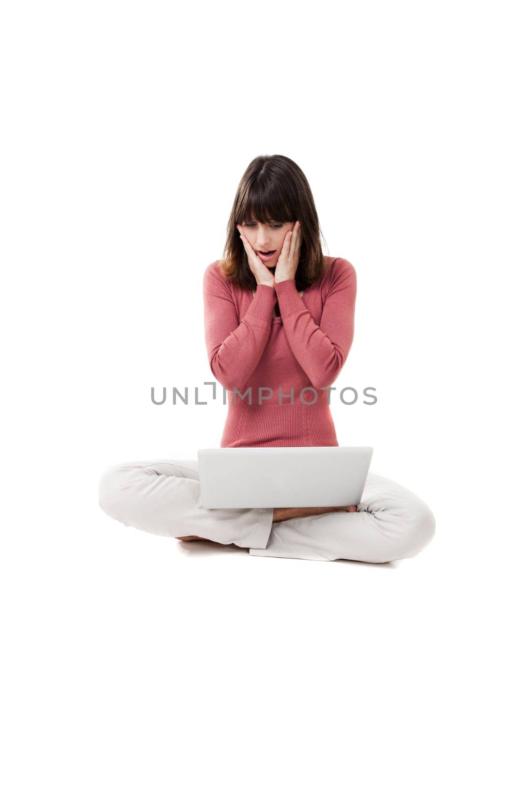 Beautiful woman surprised, with a laptop in studio with white background
