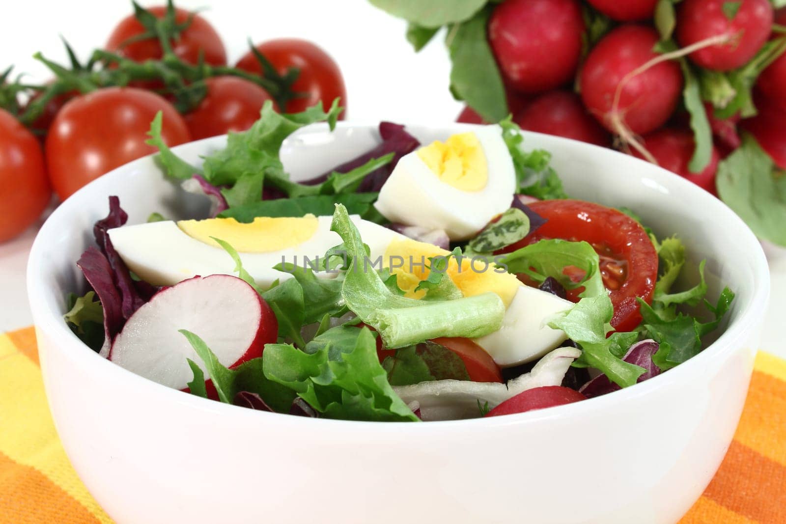 a white bowl of mixed salad