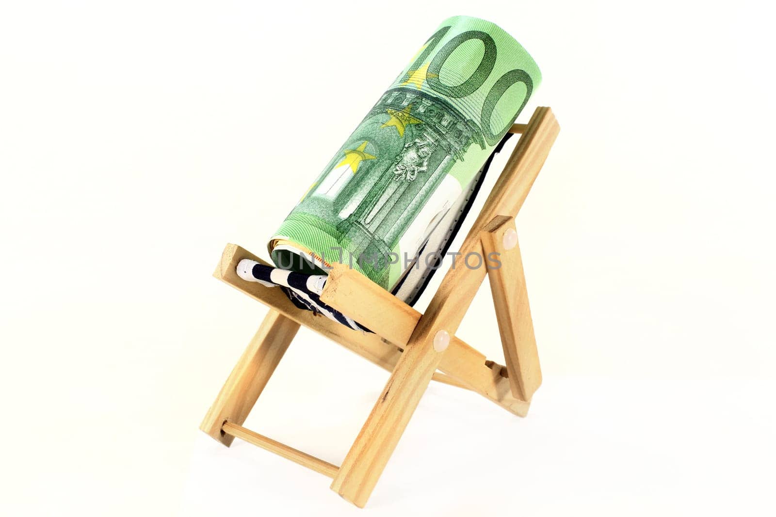 A deckchair with euro notes against a white background