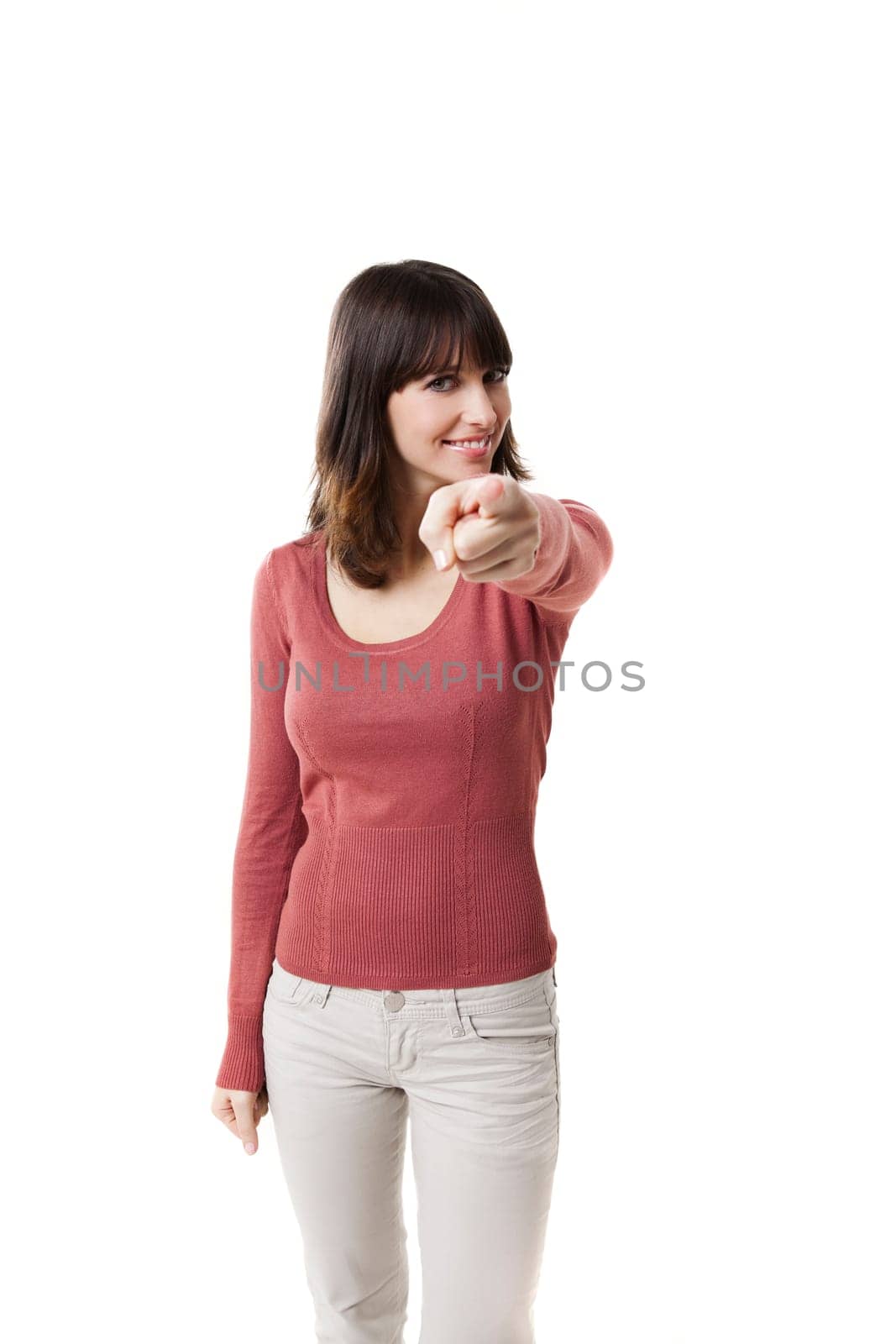 Beautiful woman pointing with finger and smiling. Studio shot with isolated white background.