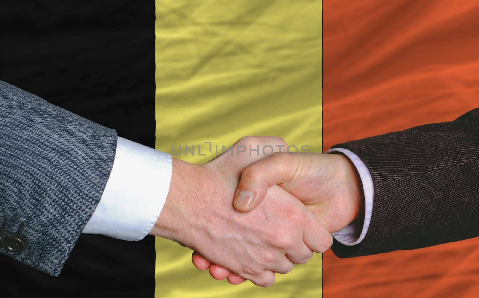 businessmen handshakeafter good deal in front of belgium flag