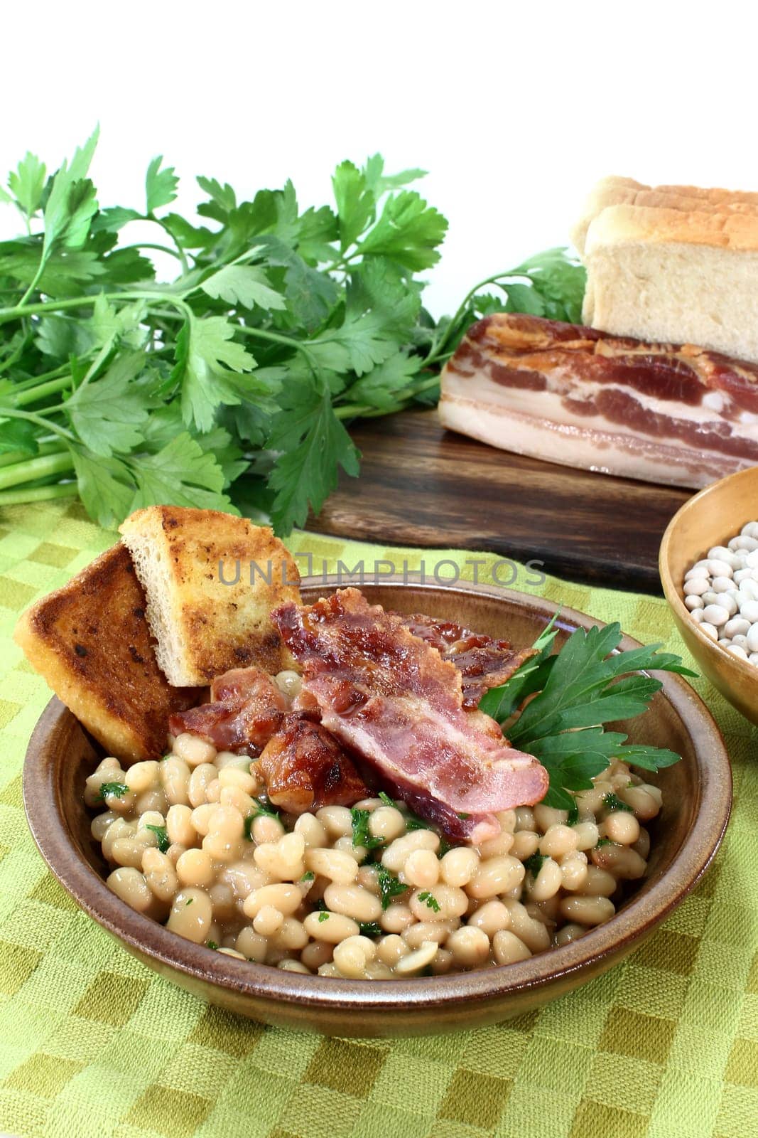 a bowl of white beans and fried bacon