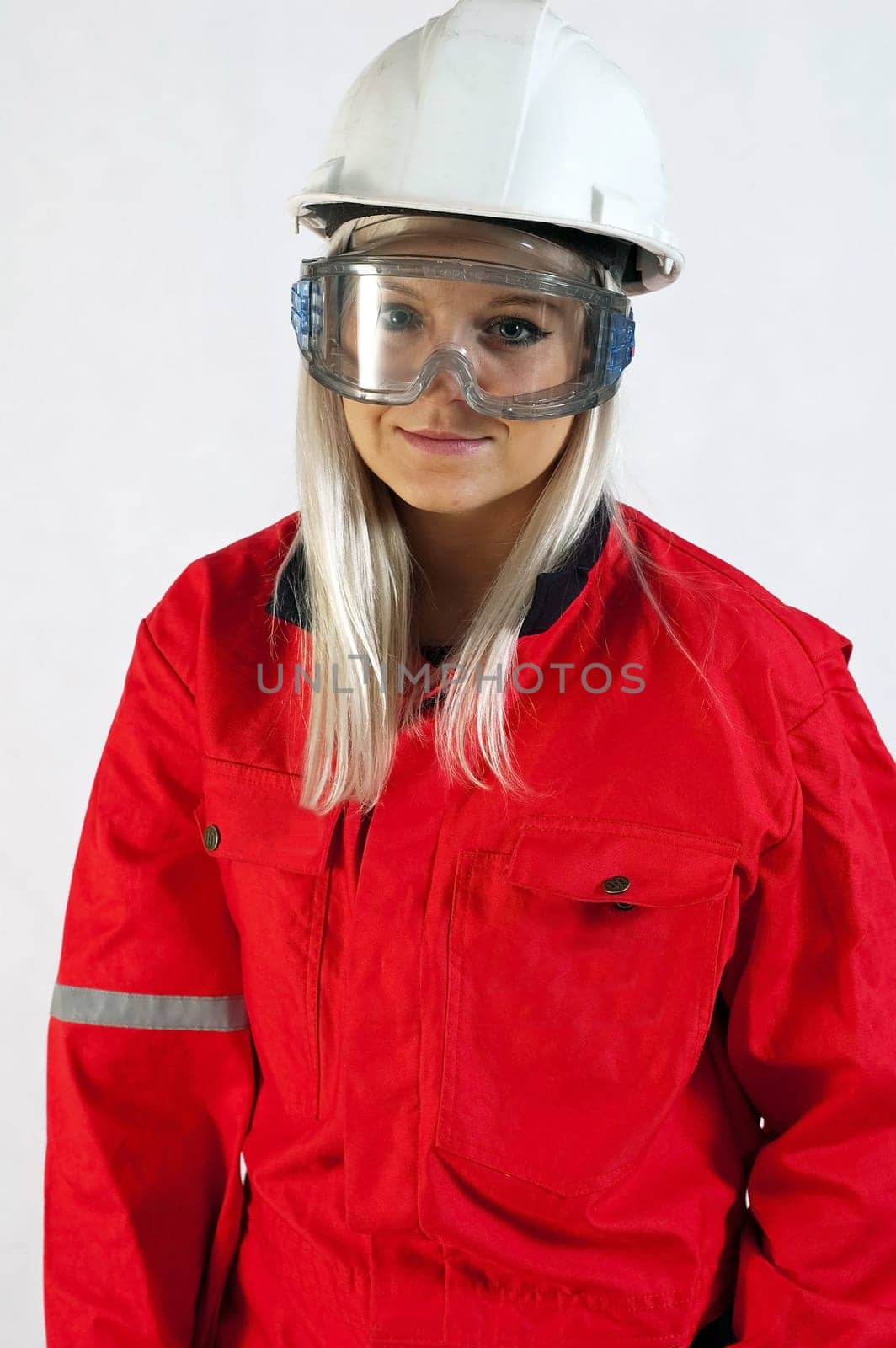 young woman builder in white helmet holding driller