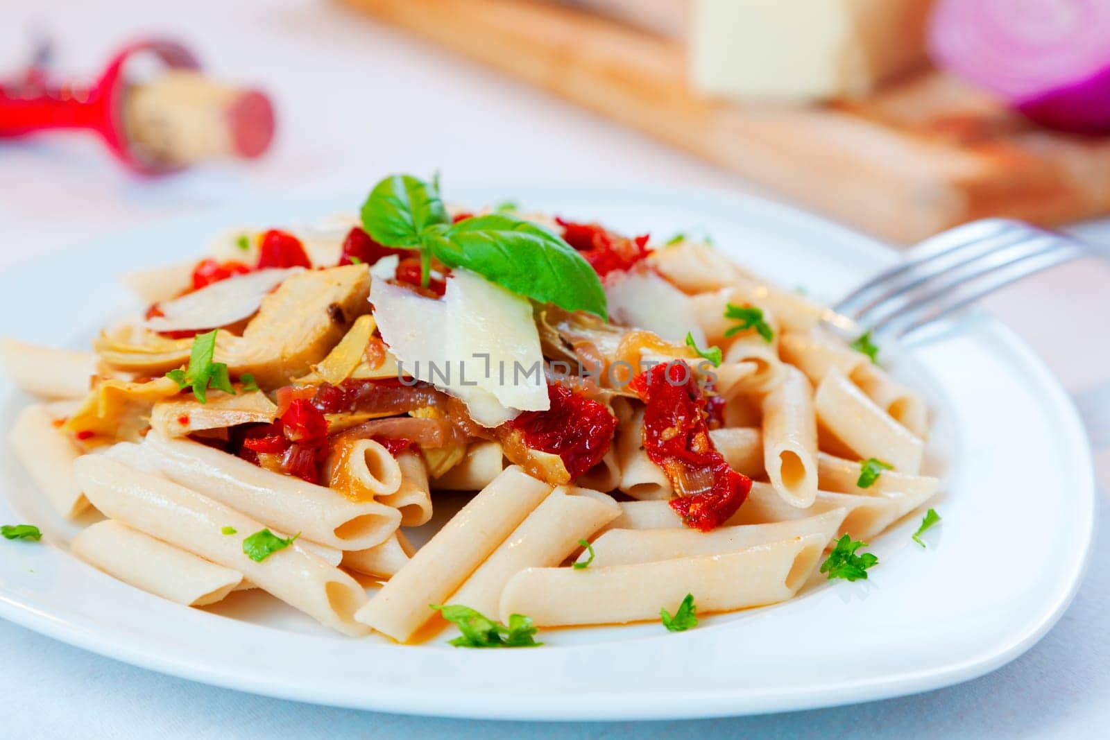 Closeup image of a pasta dish with sundried tomatoes and caramelized onions