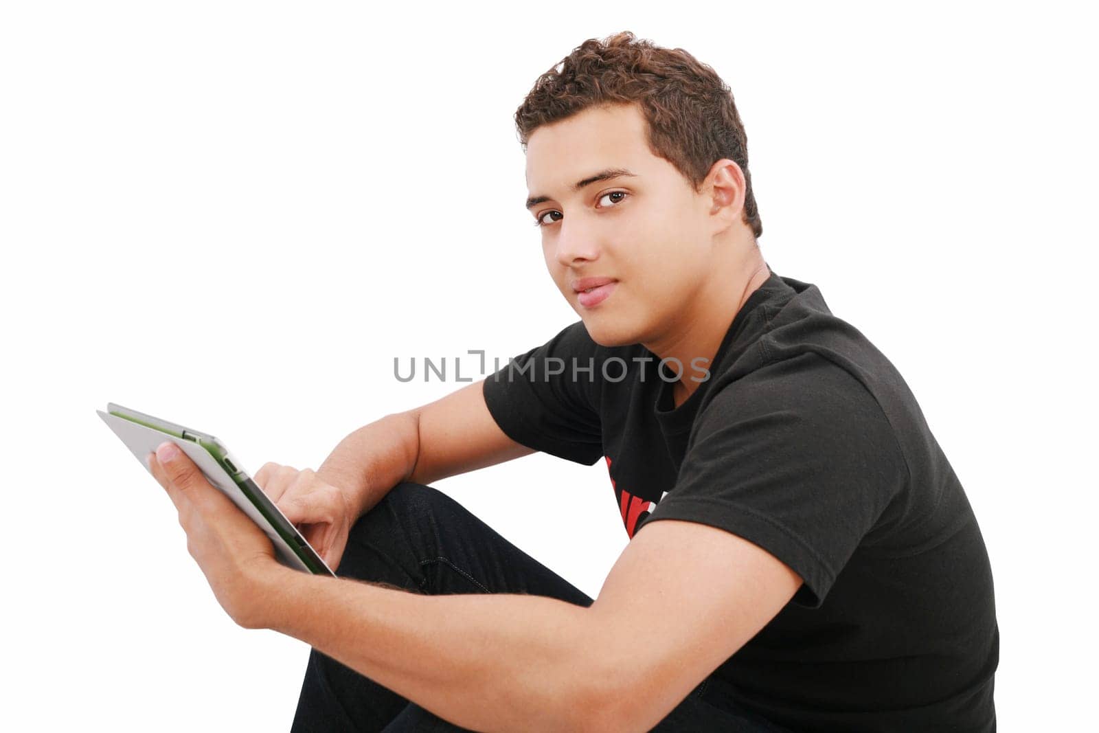 A smiling man sitting on the floor with a tablet, isolated on white