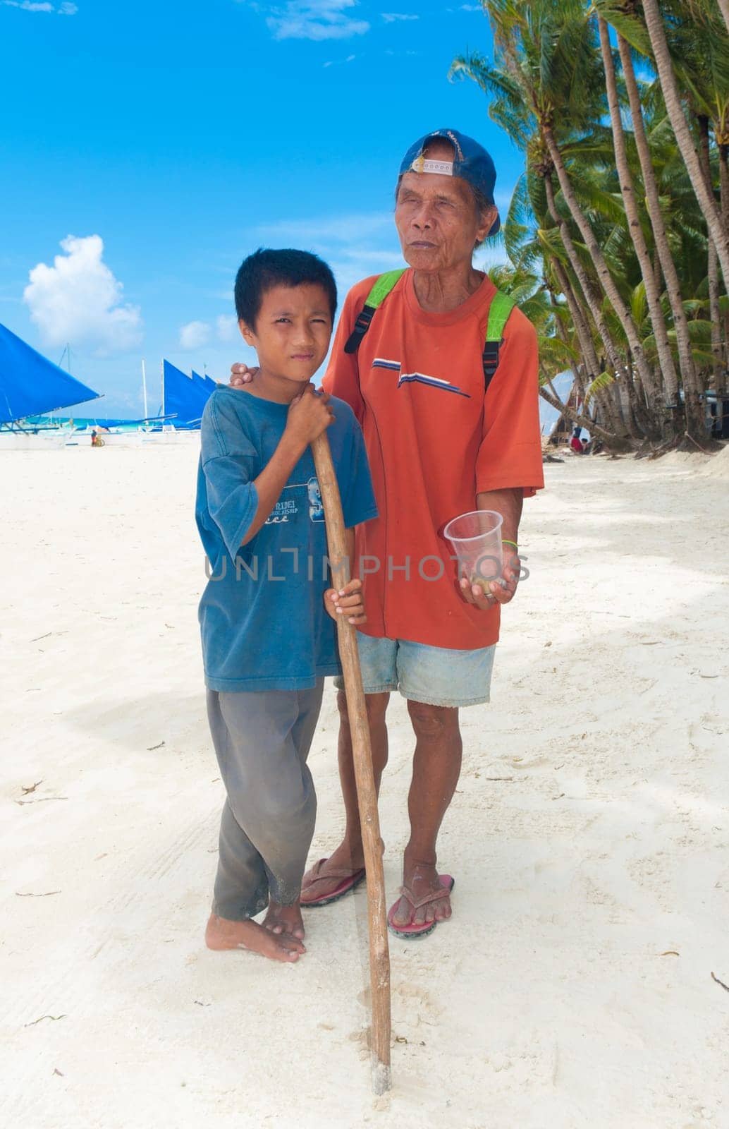 BORACAY ISLAND, PHILIPPINES - SEPTEMBER 05: Blind man with his son begging for money on September 05, 2011 on Boracay , Philippines. With no social securities this country is one of the poorest of south-east asia with over one million people living on the