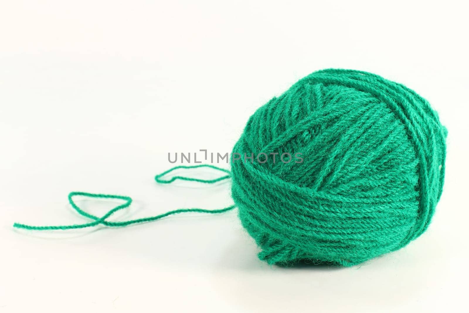 a green ball of wool against a white background
