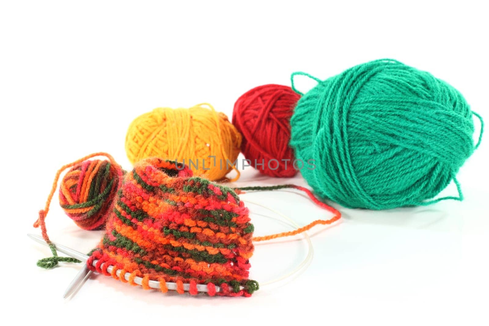 some colorful balls of wool with a knitting sample