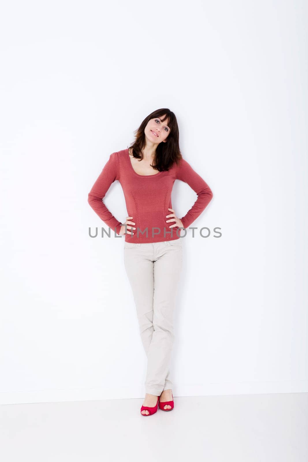 Beautiful woman standing with red shoes. Studio shot.