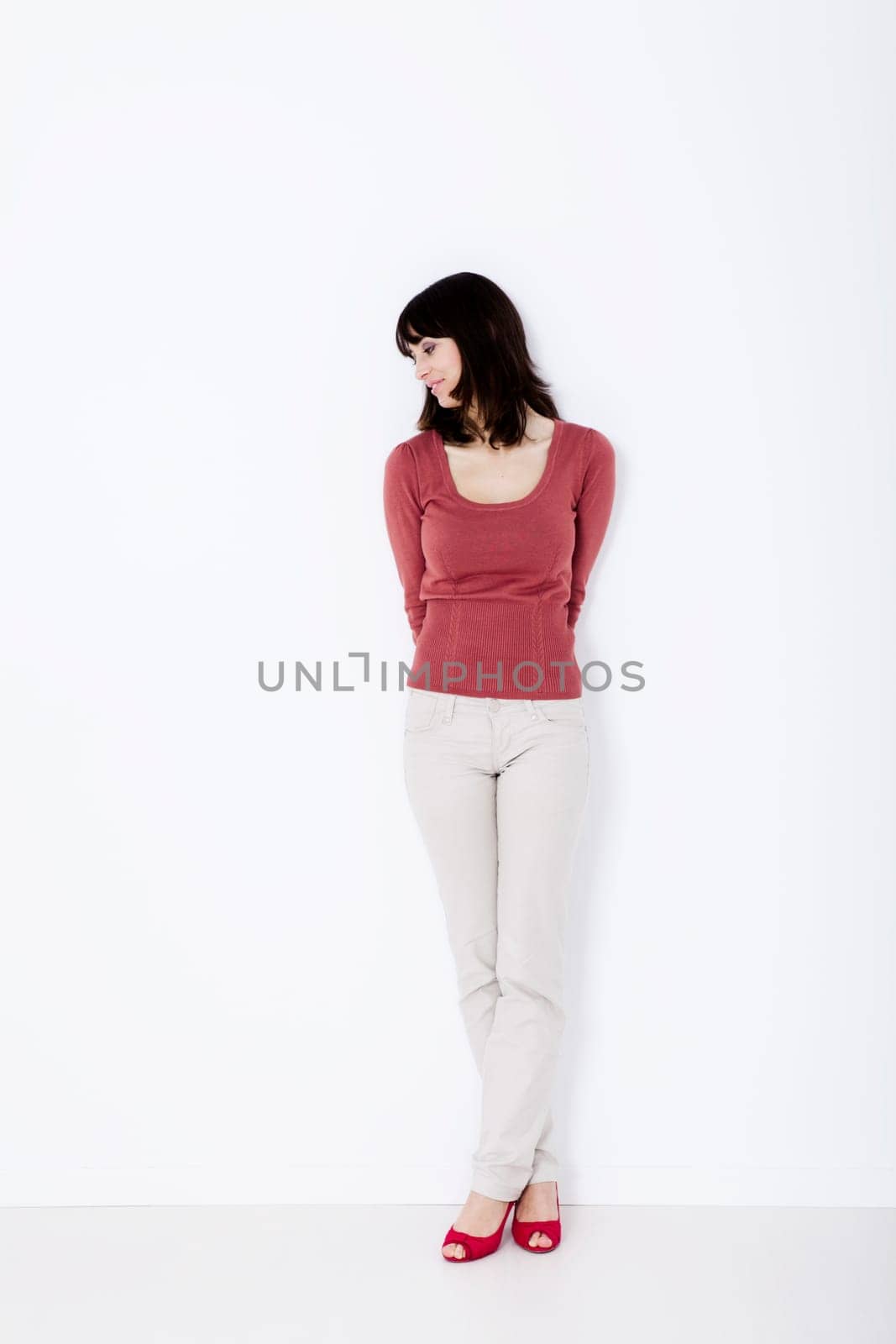 Beautiful woman standing and looking down. Studio shot.