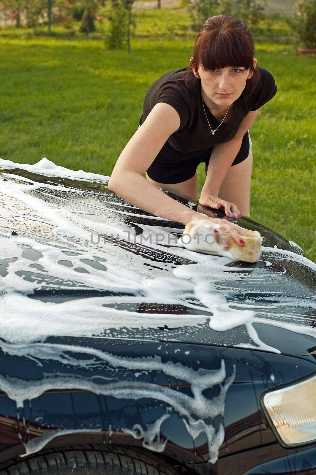 Adult cleaning her car outside