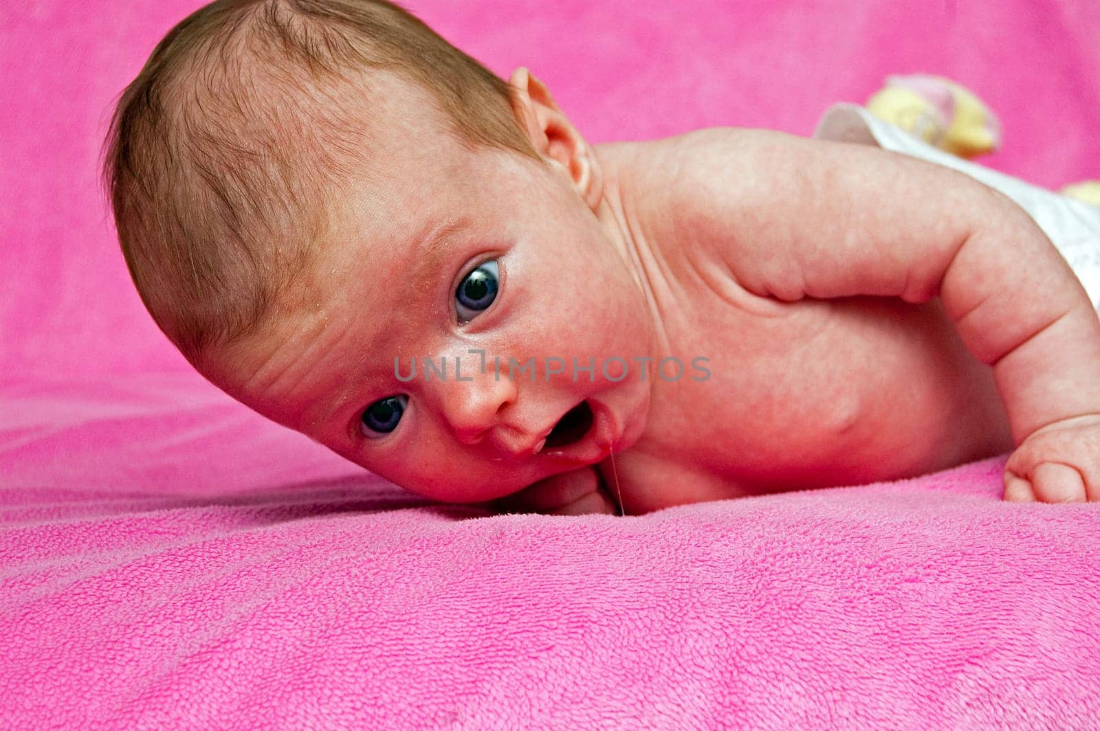Baby lying on her tummy and a pink blanket
