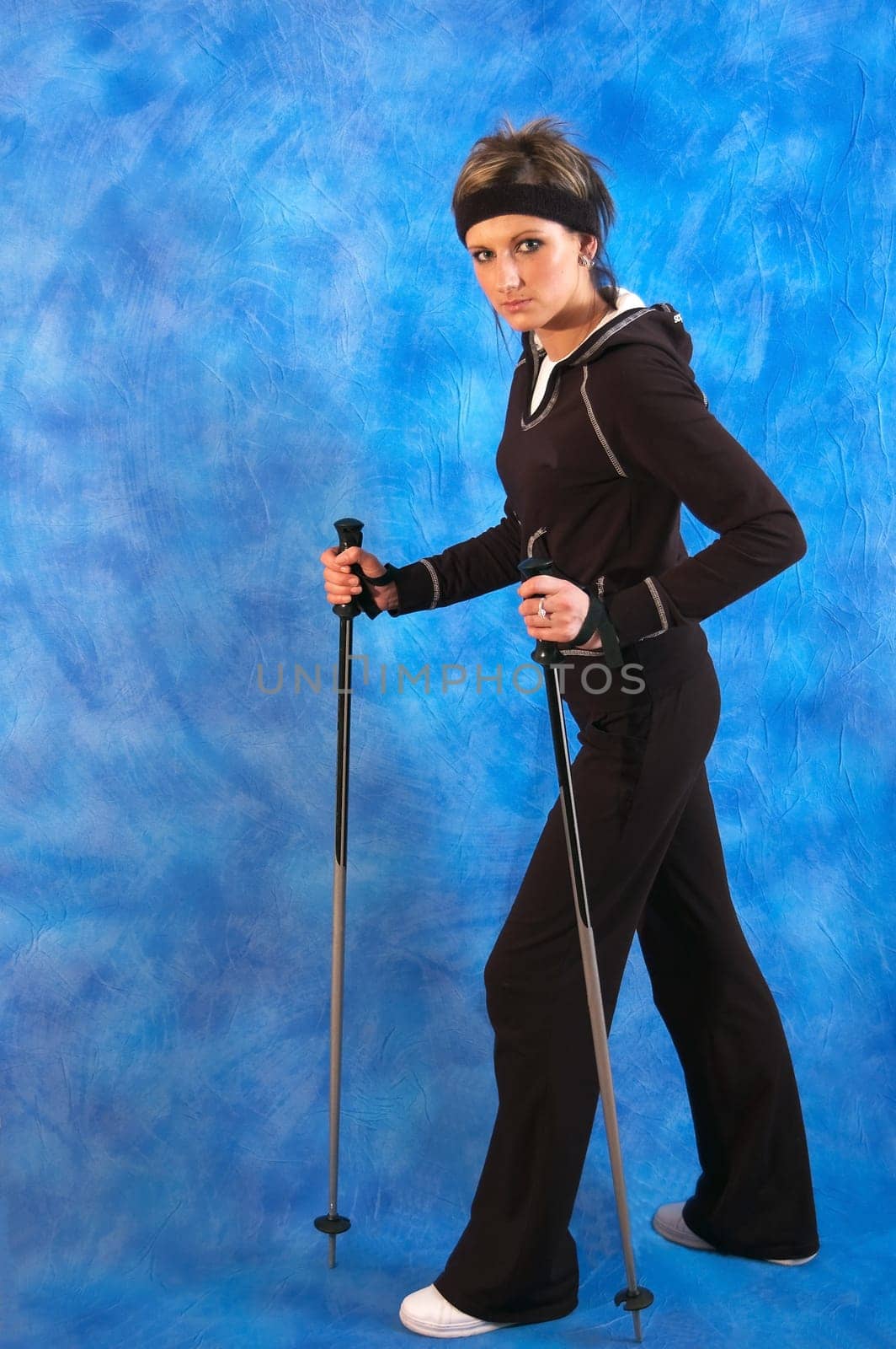 Young woman nordic walking on the blue mosaic background